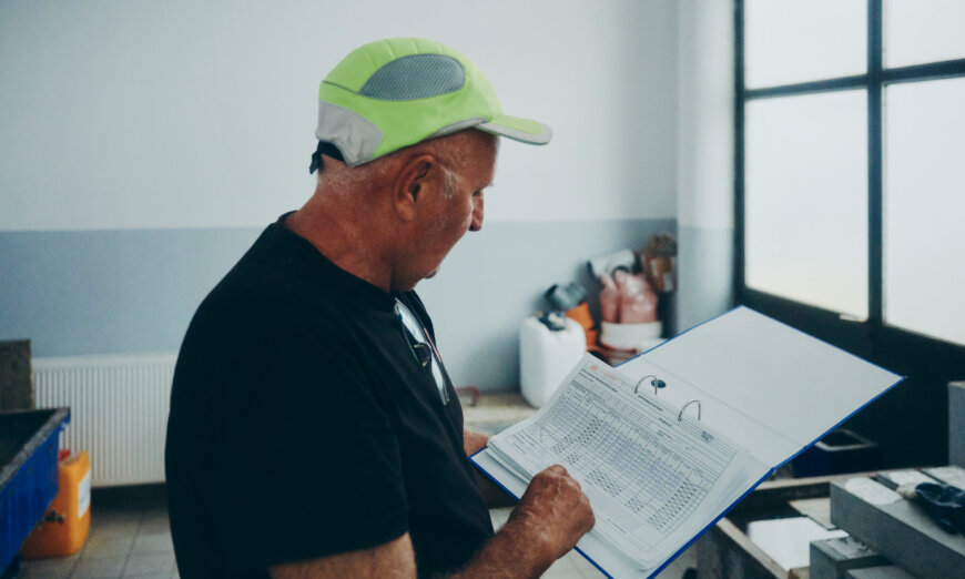 moll-rail-croatia-man-wearing-a-cap-reviewing-documents-in-a-folder