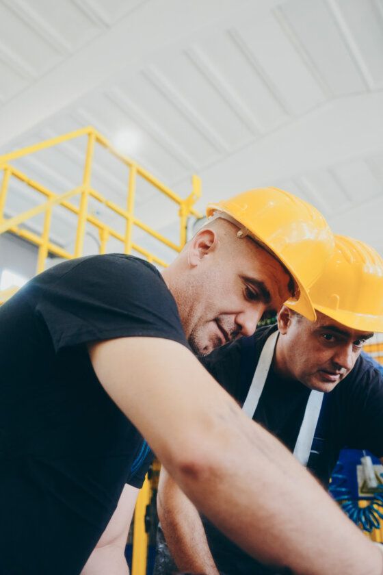moll-rail-croatia-two-factory-workers-wearing-yellow-hard-hats-inspecting-equipment