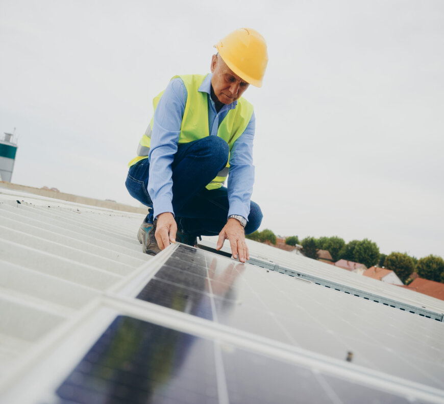 moll-rail-croatia-worker-in-hard-hat-inspecting-solar-panels-on-a-roof